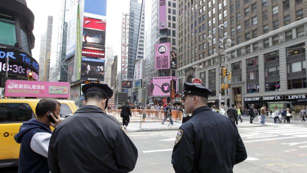 epa03664565 Members of the New York Police Department (C) are seen on patrol in Times Square in New York, New York, USA, 16 April 2013. Heightened security is seen in Times Square following the explosions in Boston on 15 April. EPA/JASON SZENES