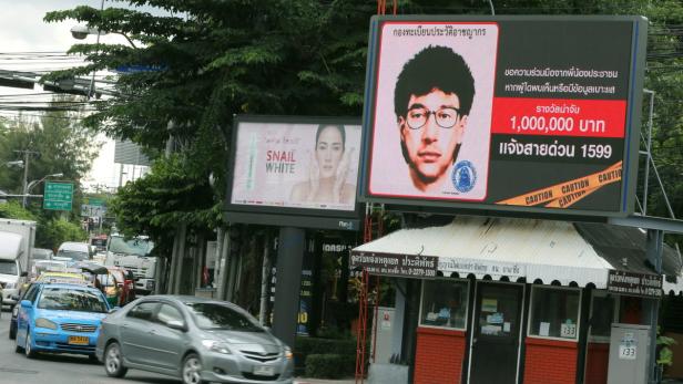 In Bangkok steht eine Fahndungstafel mit dem Foto eines Mannes und einer Belohnung von 1.000.000 Baht.