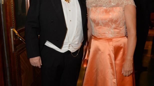 Ein Mann im Frack mit einer Ordensdekoration und eine Frau in einem apricotfarbenen Abendkleid posieren für ein Foto.