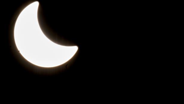 Eine partielle Sonnenfinsternis vor einem schwarzen Hintergrund.