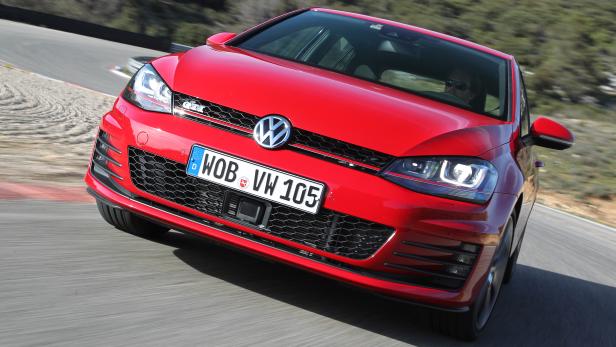 Ein roter VW Golf GTI fährt auf einer Rennstrecke.