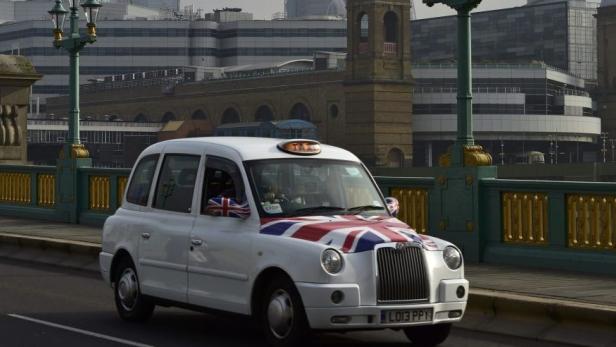 A London cab decorated in the Union Flag crosses S
