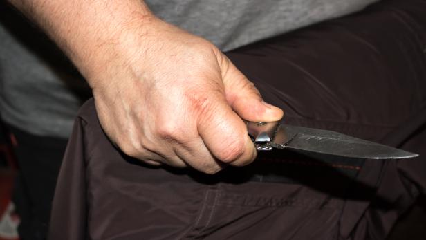 Closeup of a young man hand, holding a knife, about to attack