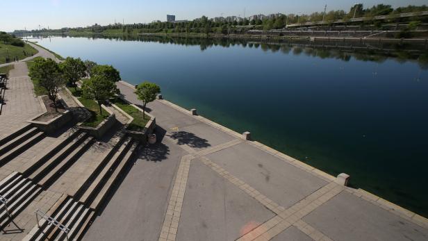 TOD VON LIBYENS EX-PREMIER: GHANEM IN NEUER DONAU Blick auf die Neue Donau in Wien mit Uferpromenade und Treppen.