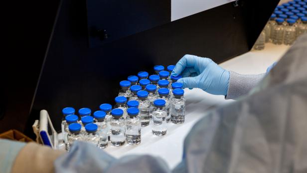 A lab technician inspects filled vials of investigational remdesivir at a Gilead Sciences facility in La Verne
