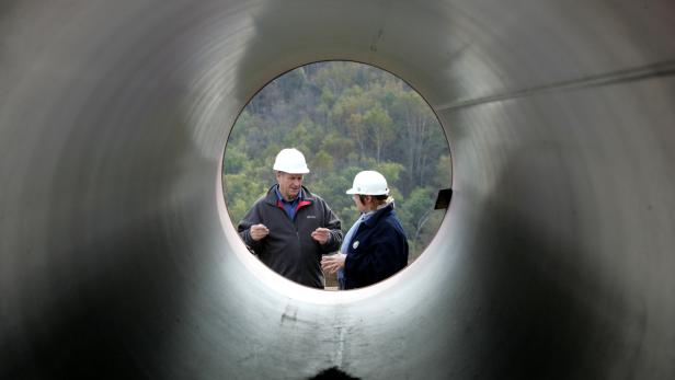 FILE PHOTO: Engineers talk standing next to pipes at a pipeline building site of the Sakhalin-2 project north of Yuzhno-Sakhalinsk