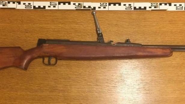 Ein Luftgewehr liegt auf einem Holztisch.