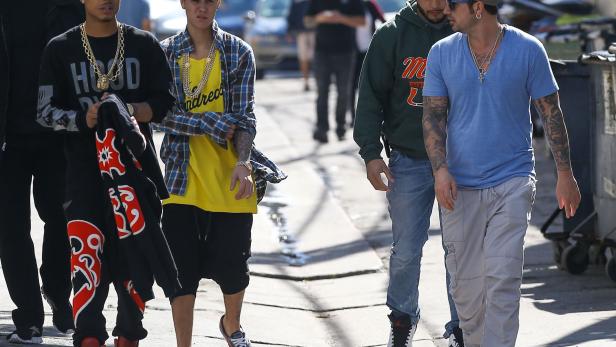 Justin Bieber geht mit einigen Begleitern die Straße entlang.