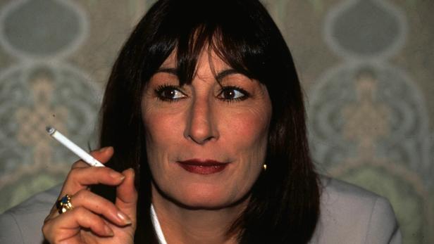 Anjelica Huston hält eine Zigarette in der Hand.