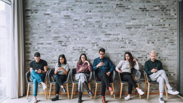 businesspeople using cell phone while sitting in chair