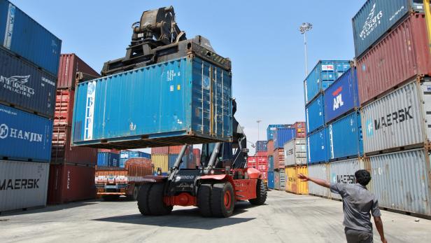 FILE PHOTO: A mobile crane prepares to stack a container at a port in Chennai