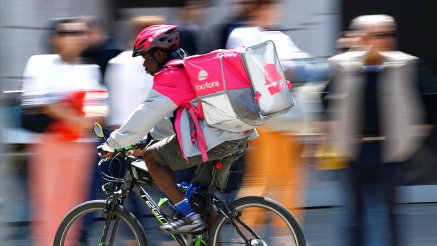 Foodora-Essenslieferant auf einem Fahrrad.