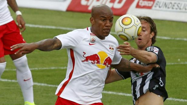 Zwei Fußballspieler kämpfen um den Ball während eines Spiels.