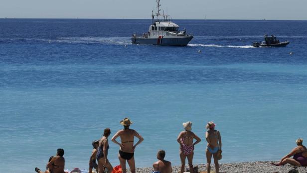 Bilder aus Nizza: Badegäste am Strand und Patrouillenboote im Meer