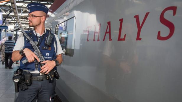 Ein bewaffneter Polizist steht vor einem Thalys-Zug.
