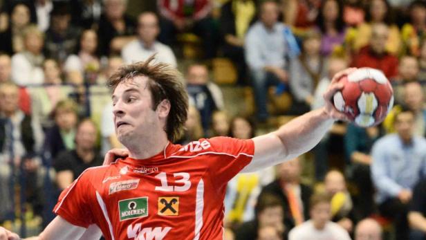Ein Handballspieler im roten Trikot mit der Nummer 13 wirft einen Ball.