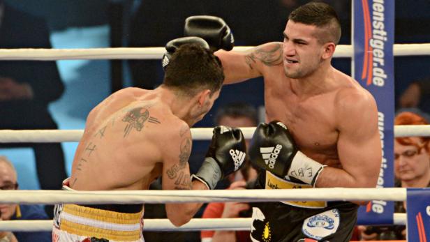 Ein Boxer schlägt seinen Gegner im Ring.