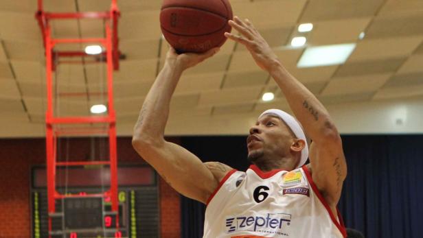 Ein Basketballspieler mit Trikot Nummer 6 wirft einen Ball in Richtung Korb.