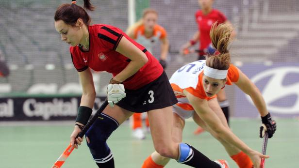 Zwei Hockeyspielerinnen kämpfen um den Ball während eines Spiels.
