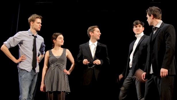 Fünf Schauspieler stehen auf einer Bühne vor einem schwarzen Hintergrund.