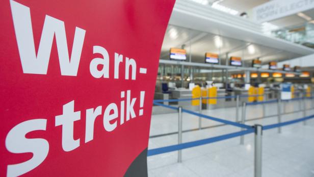 Ein Plakat mit der Aufschrift «Warnstreik!» ist am 22.04.2013 vor mehreren Check-In-Schaltern der Lufthansa im Münchner Flughafen (Bayern) zu sehen. Es ist bereits die zweite Welle von Arbeitsniederlegungen in dem Tarifkonflikt um Entgelte und Arbeitsbedingungen von rund 33.000 Technikern und Serviceleuten. Die Lufthansa hat mit radikalen Streichungen im Flugplan auf die angekündigten Warnstreiks der Gewerkschaft Verdi reagiert. Foto: Marc Müller/dpa +++(c) dpa - Bildfunk+++