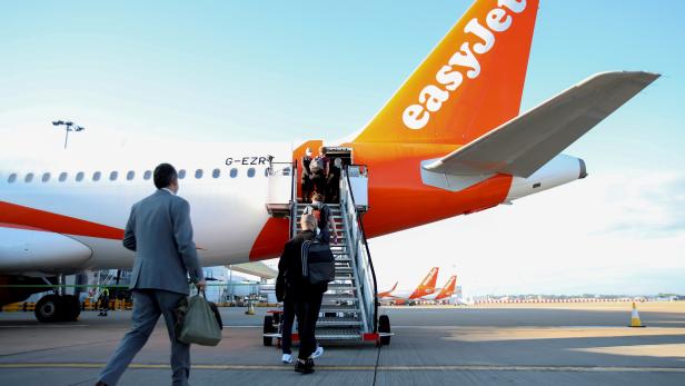 FILE PHOTO: Passengers board a plane as easyJet restarts its operations at Gatwick Airport
