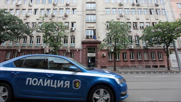 A police car passes past Bulgaria's National Revenue Agency building in Sofia
