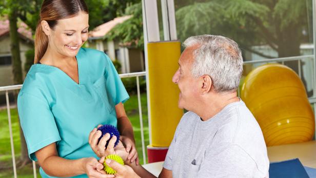 Senior mit Igelball bei Physiotherapie