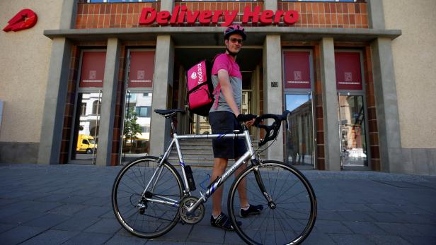 FILE PHOTO: A Foodora delivery cyclist poses in front of Delivery Hero headquarters in Berlin