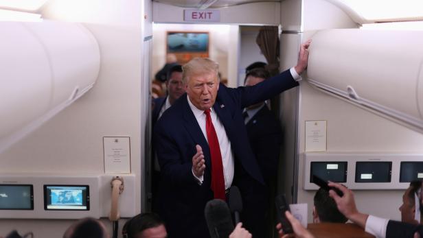 U.S. President Donald Trump talks to reporters on aboard Air Force One as he returns from New Hampshire to Washington, U.S