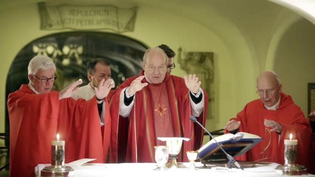 Drei Priester zelebrieren eine Messe in einer Kirche.