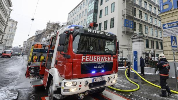 Ein rotes Feuerwehrfahrzeug der Wiener Feuerwehr steht auf einer Straße.