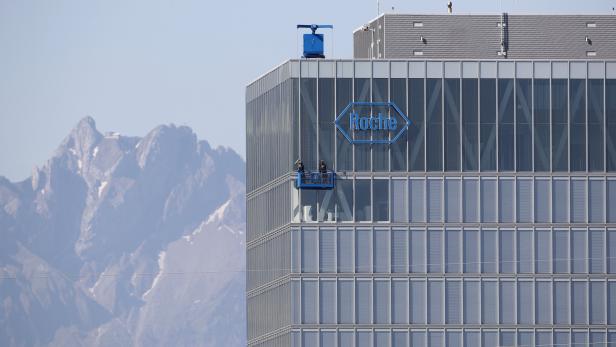 Workers clean windows of a building of Roche in Rotkreuz