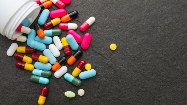 Many pills and tablets on black background.