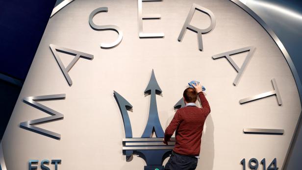 A worker cleans Maserati logo at Brussels Motor Show