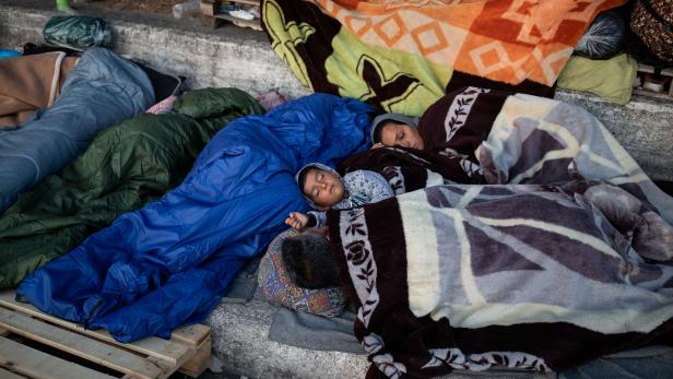 Refugees and migrants from the destroyed Moria camp sleep on the side of a road, on the island of Lesbos