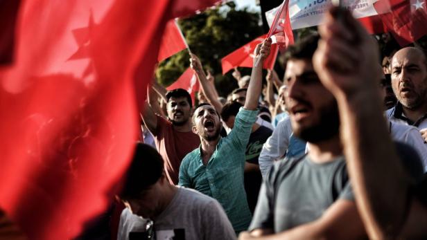 Eine Menschenmenge demonstriert mit türkischen Flaggen.