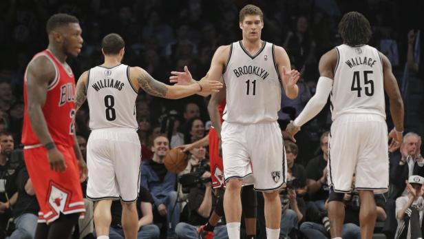 Brooklyn Nets guard Deron Williams (8), center Brook Lopez (11) and forward Gerald Wallace (45) tap hands as Chicago Bulls point guard Nate Robinson walks off the court in the fourth quarter of their NBA basketball playoff game in New York, April 29, 2013. REUTERS/Ray Stubblebine (UNITED STATES - Tags: SPORT BASKETBALL)