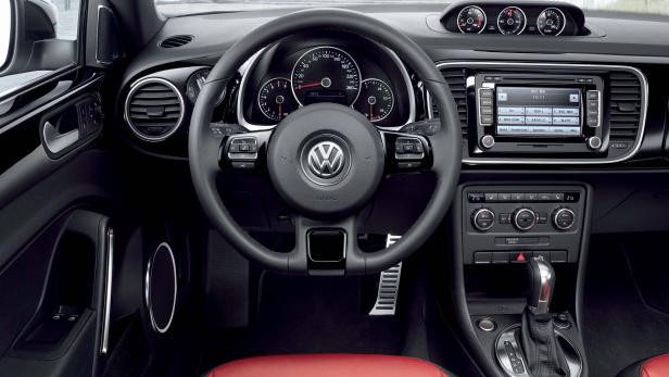 Das Interieur eines Volkswagen Beetle mit roten Ledersitzen.