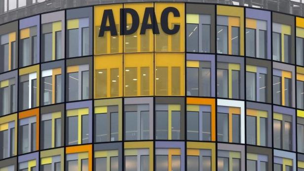 Das ADAC-Logo ist an einem Gebäude mit bunten Fenstern angebracht.