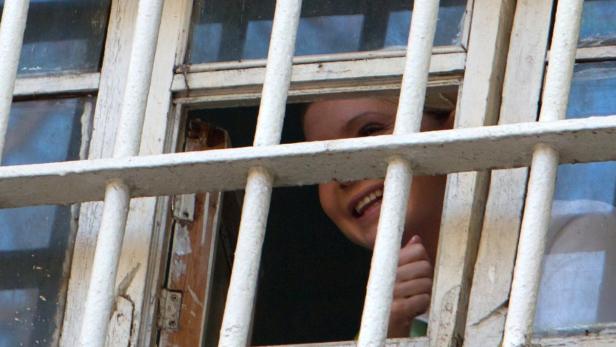 File picture shows Ukrainian former prime minister Yulia Tymoshenko through a prison window in Kiev November 4, 2011. Despite winning rare praise from the West for freeing an opponent from jail, Ukrainian President Viktor Yanukovich is likely to resist extra pressure and the lure of trade deals to release his fiercest rival, ex-prime minister Yulia Tymoshenko. Though he has pardoned former interior minister Yuri Lutsenko, a Tymoshenko ally, that will not be enough to satisfy European Union demands for democratic reform and clinch association and free-trade agreements with the 27-member bloc in November, at a summit in the Lithuanian capital Vilnius. Picture taken November 4, 2011. TO GO WITH STORY UKRAINE-POLITICS/ REUTERS/Inna Sokolovska/File (UKRAINE - Tags: CRIME LAW POLITICS)