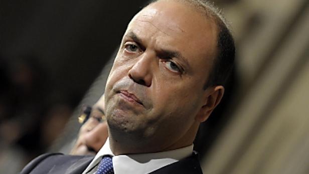 Ein Mann im Anzug blickt aufmerksam zur Seite.