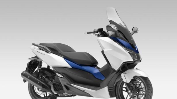 Ein weißer und blauer Honda Forza Motorroller steht vor einem neutralen Hintergrund.