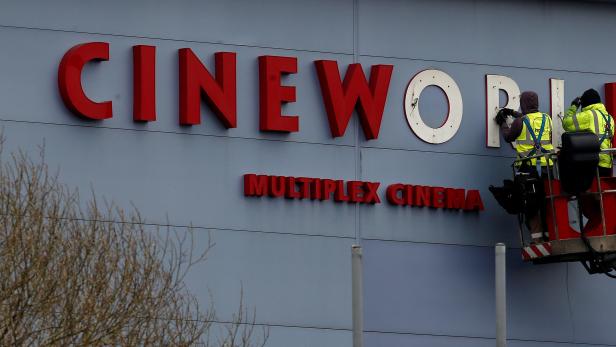 FILE PHOTO: FILE PHOTO Workers repair a sign at a Cineworld cinema in Bradford northern England.