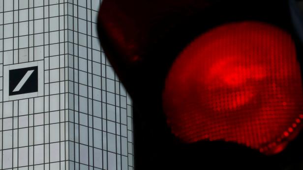 FILE PHOTO: A red traffic lights is seen next to the headquarters of Germany's Deutsche Bank in Frankfurt