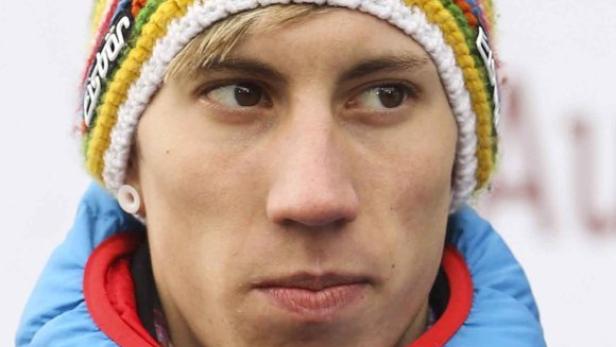 Ein junger Mann mit einer bunten Mütze und einer blauen Jacke.
