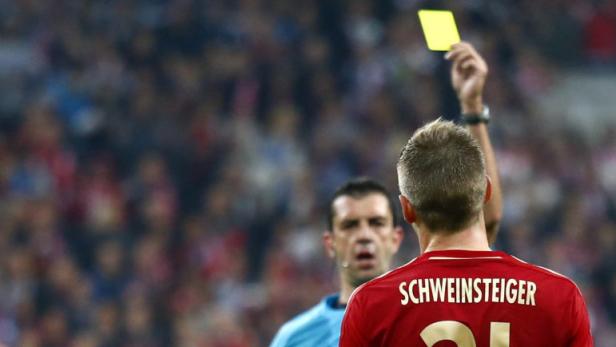 Bayern Munich&#039;s Bastian Schweinsteiger is shown a yellow card by referee Viktor Kassai (C) during their Champions League semi-final first leg soccer match against Barcelona at Arena stadium in Munich April 23, 2013. REUTERS/Michaela Rehle (GERMANY - Tags: SPORT SOCCER)