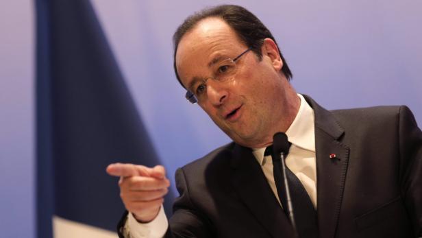 François Hollande spricht vor einer französischen Flagge.