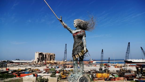 Eine Statue aus Trümmern und Glas am Randes des zerstörten Hafenviertels