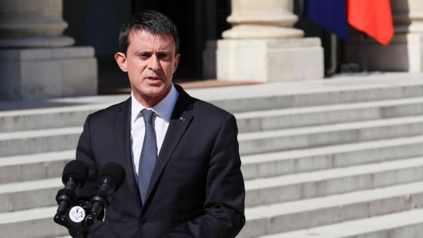 Manuel Valls spricht vor Mikrofonen im Freien.